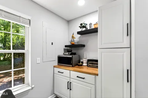 a kitchen with white cabinets and window