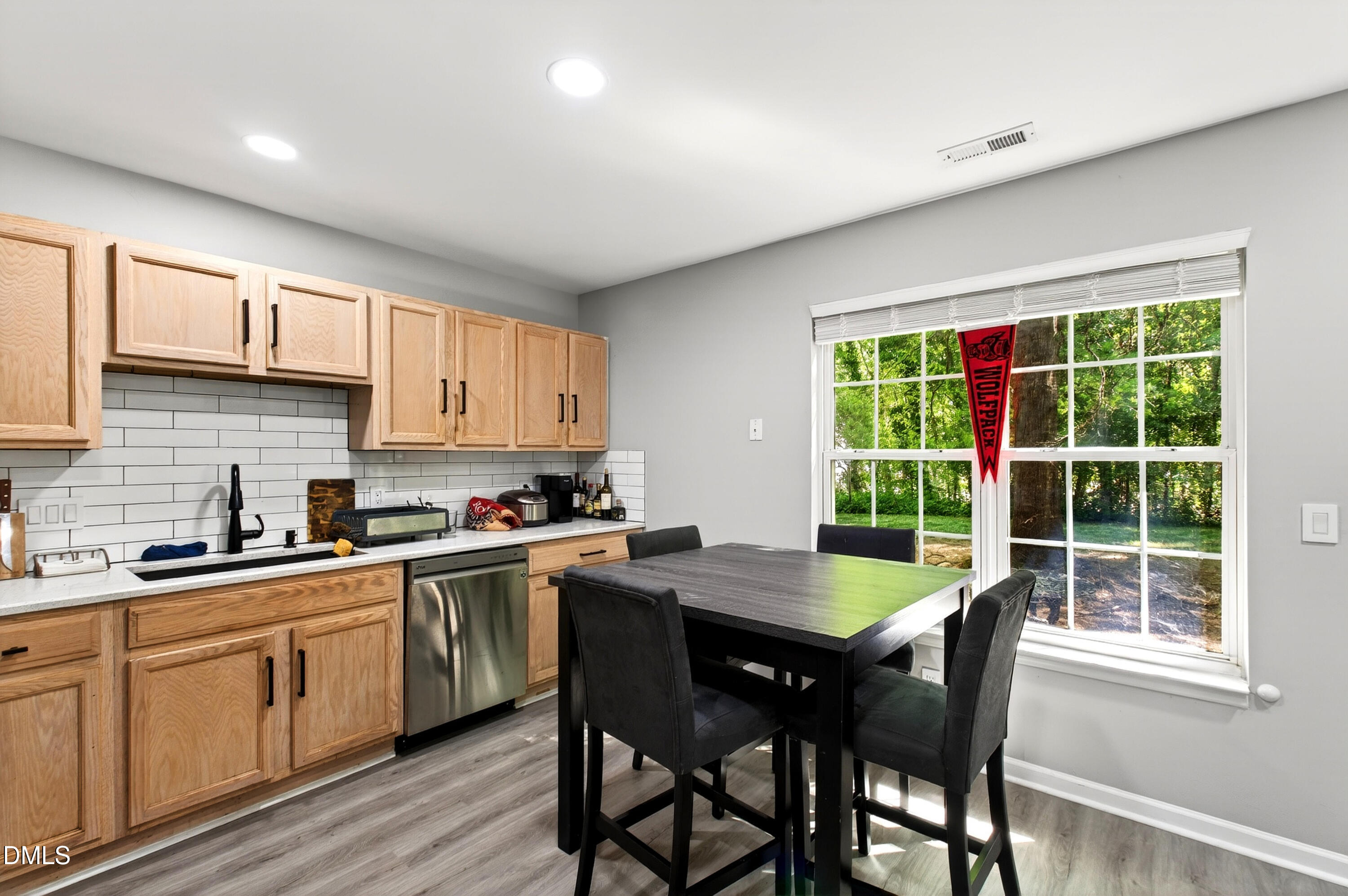 37 Red Lane Raleigh, NC 27606 - Photo 9 of 32 a kitchen with stainless steel appliances granite countertop a stove a sink dishwasher a microwave oven with a dining table and chairs