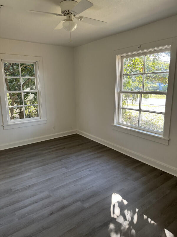 324 Dixie Street Crestview, FL 32536 - Photo 3 of 8 an empty room with wooden floor and windows