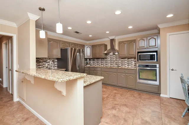 a large kitchen with kitchen island granite countertop a refrigerator and a sink
