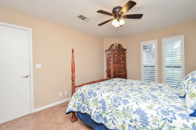 a bedroom with a bed chandelier and a window