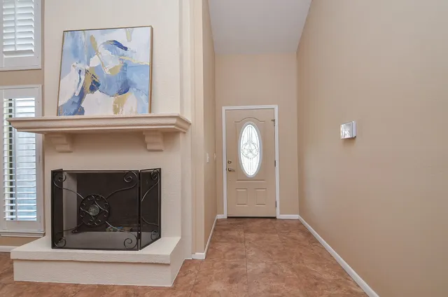 a living room with furniture a fireplace and a chandelier