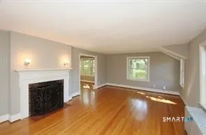an empty room with windows and a fireplace
