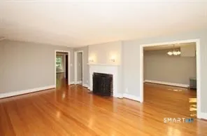 a view of a livingroom with wooden floor and a fireplace