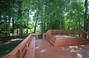 a view of backyard with deck and outdoor seating