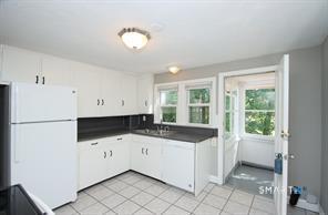 322 Deerfield Road Windsor, CT 06095 - Photo 3 of 15 a kitchen with granite countertop a sink and a stove top oven
