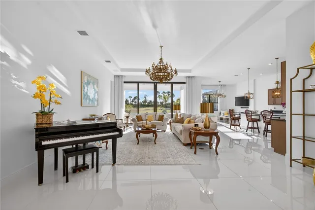 a living room with furniture kitchen view and a chandelier