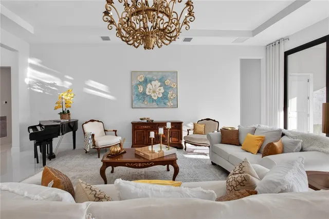 a kitchen with stainless steel appliances kitchen island granite countertop a table chairs and a view of living room