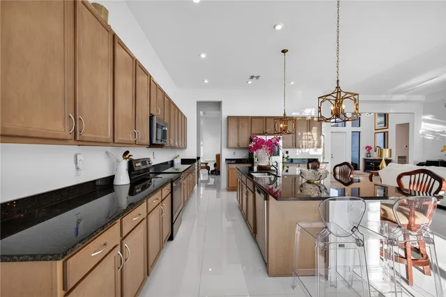 a kitchen with stainless steel appliances kitchen island granite countertop a sink and cabinets