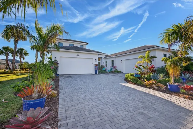 a front view of a house with a yard and potted plants