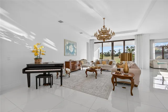 a living room with furniture a chandelier and a piano