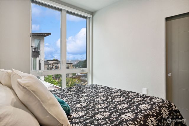a bedroom with a bed and a large mirror next to a window