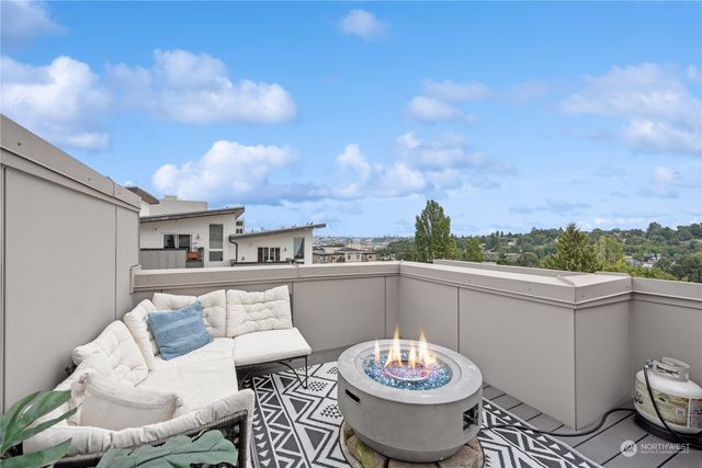 a view of a roof deck with dining table and chairs
