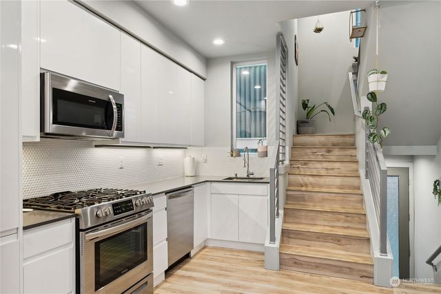 a kitchen with granite countertop a stove and a wooden floor
