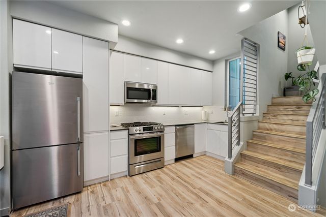 a kitchen with stainless steel appliances a refrigerator sink and microwave