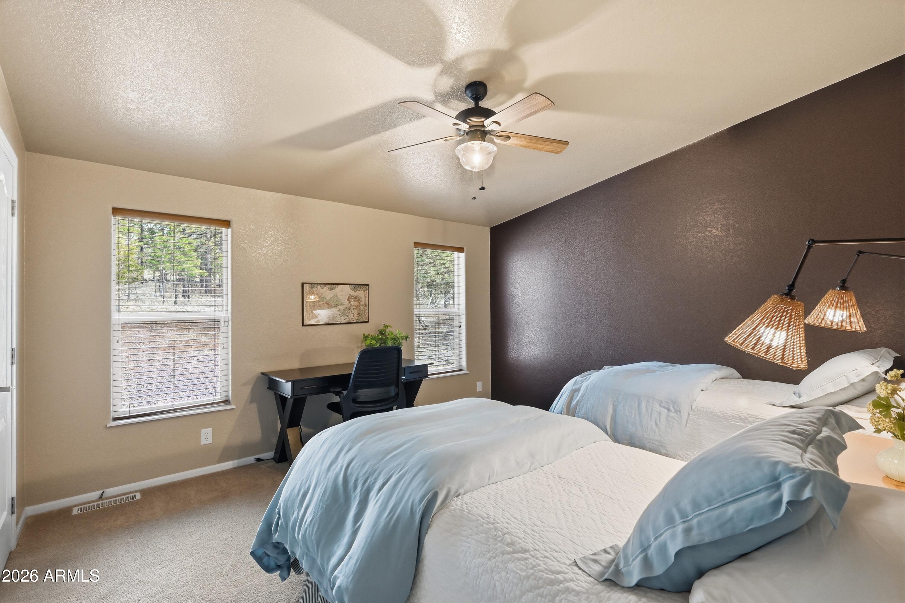 2381 Blue Ridge Drive Happy Jack, AZ 86024 - Photo 21 of 45 a bedroom with a bed and a chandelier