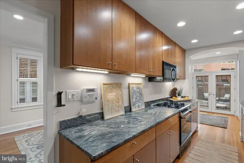 a kitchen with stainless steel appliances granite countertop a stove a sink and a microwave