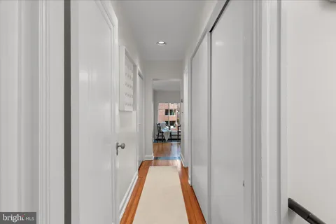 a view of a hallway with wooden floor and a livingroom