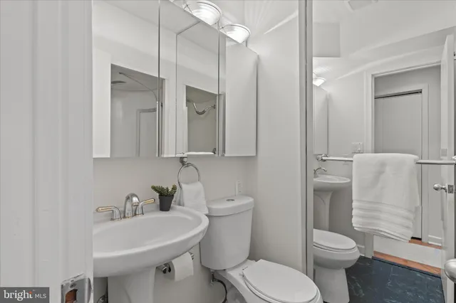 a bathroom with a toilet a sink and mirror