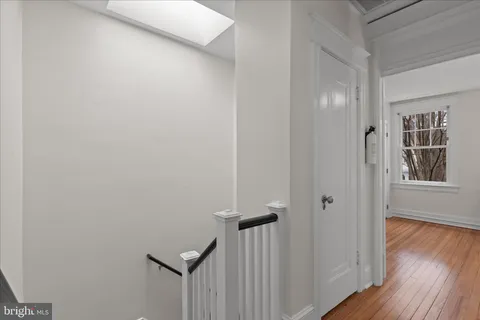 a view of a hallway with wooden floor and closet