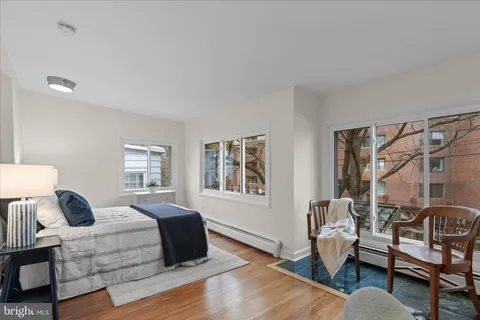 a spacious bedroom with a bed and wooden floor