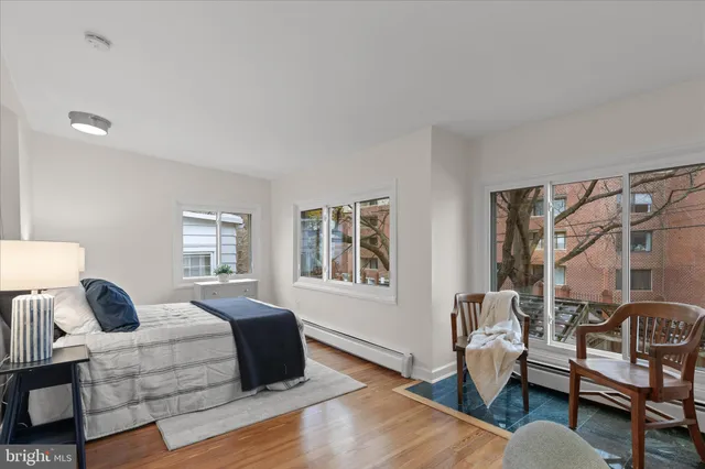 a spacious bedroom with a bed and wooden floor