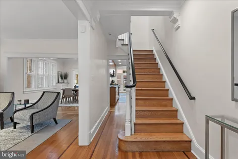 a view of entryway and hall with wooden floor