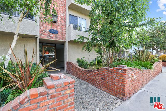 a wooden fence with plants in front of house