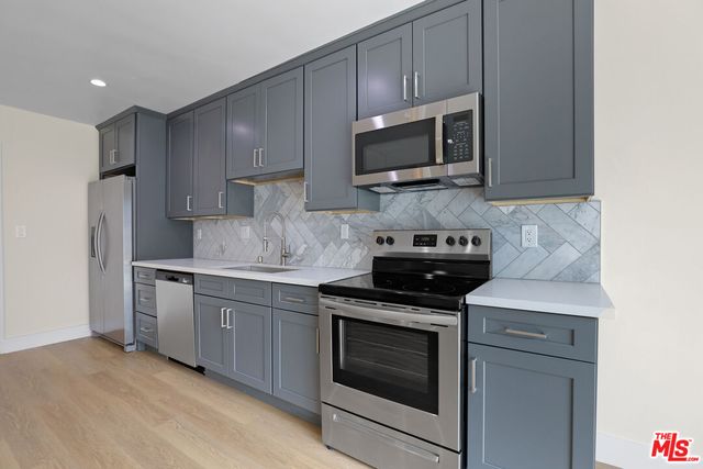 a kitchen with stainless steel appliances granite countertop a stove microwave and refrigerator