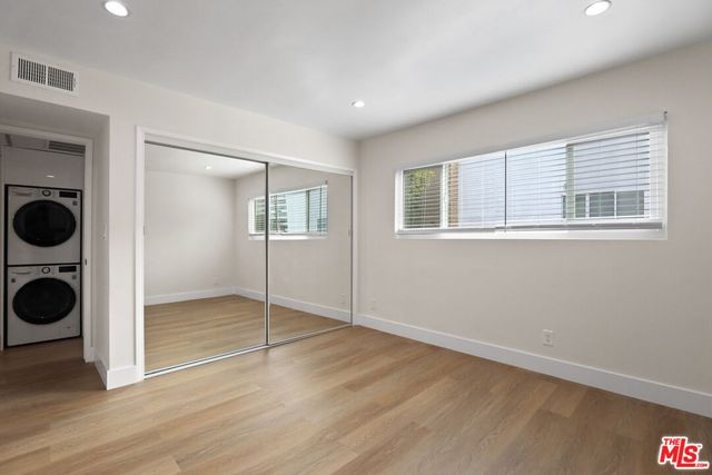 a view of a big room with wooden floor and cabinets