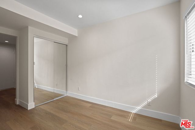 an empty room with wooden floor and door