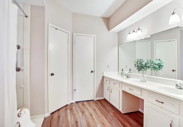 a spacious bathroom with a double vanity sink mirror and shower