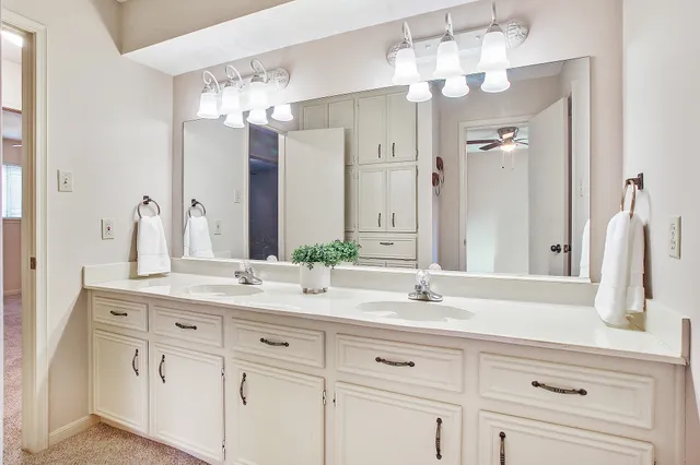 a bathroom with white cabinets and a sink