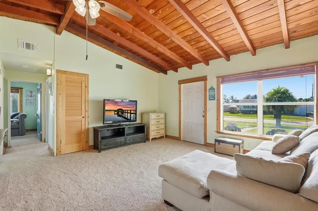 a living room with furniture a flat screen tv and a large window