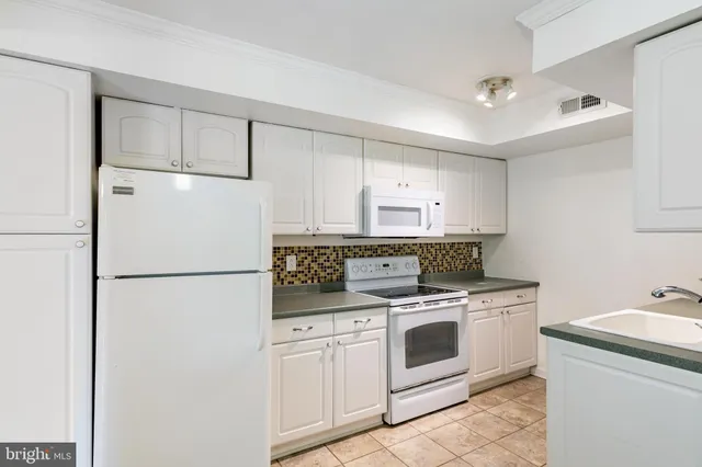 a kitchen with a stove top oven and refrigerator