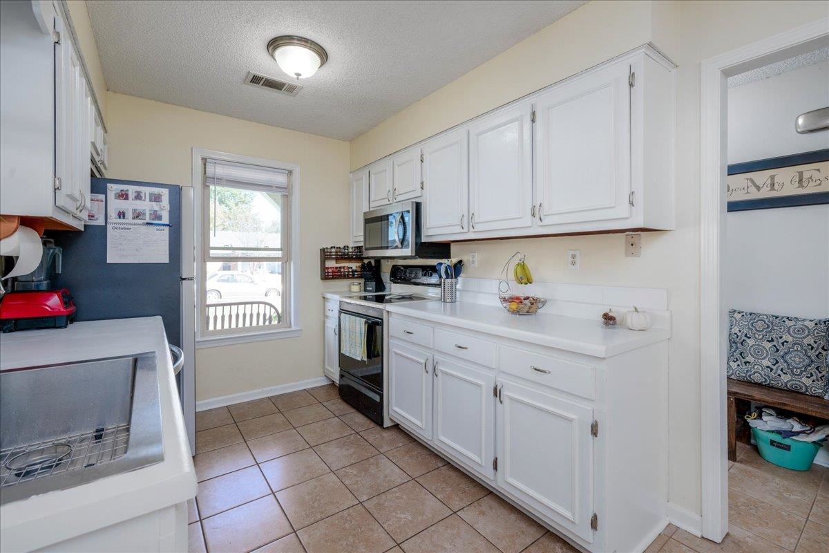 4357 Water Briar Road Millington, TN 38053 - Photo 10 of 29 Kitchen with black / electric stove, white cabinetry, light tile patterned flooring, and a textured ceiling