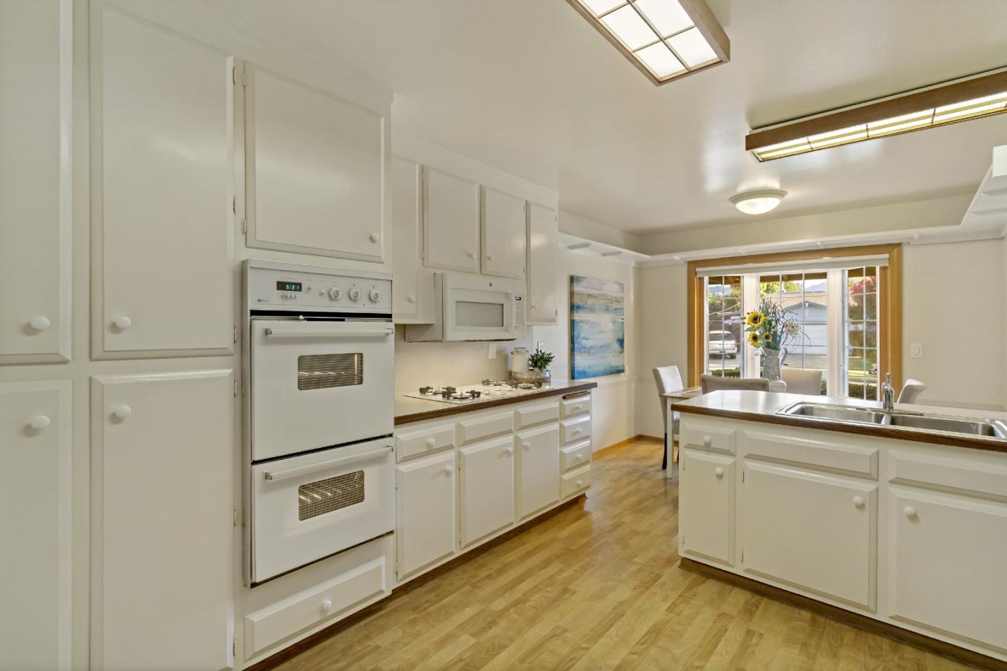 1287 Peralta Drive San Jose, CA 95120 - Photo 25 of 38 a kitchen with kitchen island white cabinets and white appliances