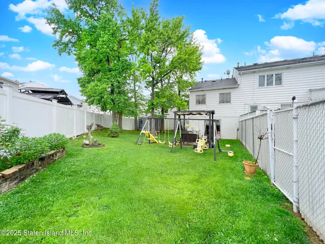 a view of a house with backyard and a tree