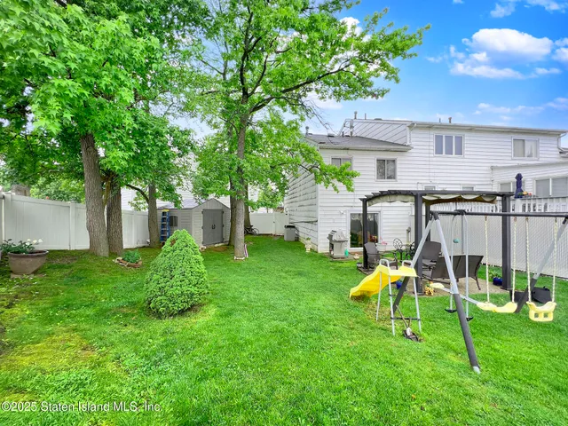 a view of a backyard with a slide and a table and chairs