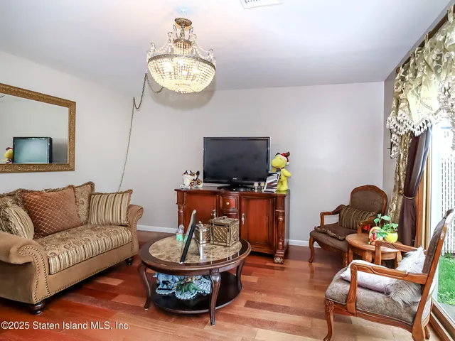 a living room with furniture a flat screen tv and a window