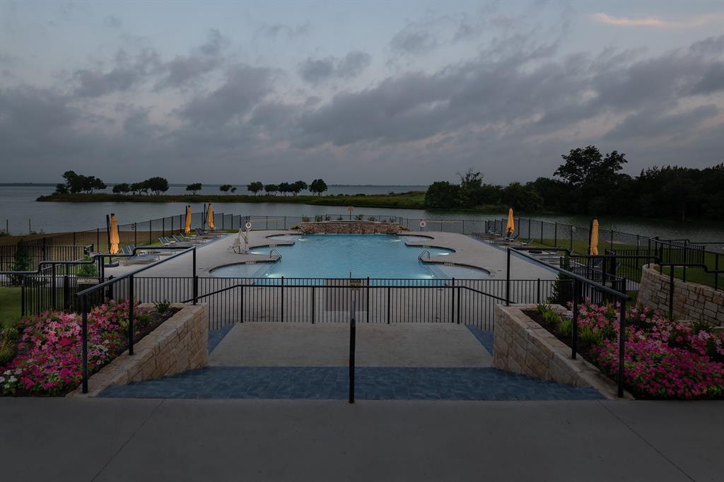 3908 Friendship Court Forney, TX 75126 - Photo 36 of 37 Multi-level swimming pool with integrated seating surrounded by a black metal fence