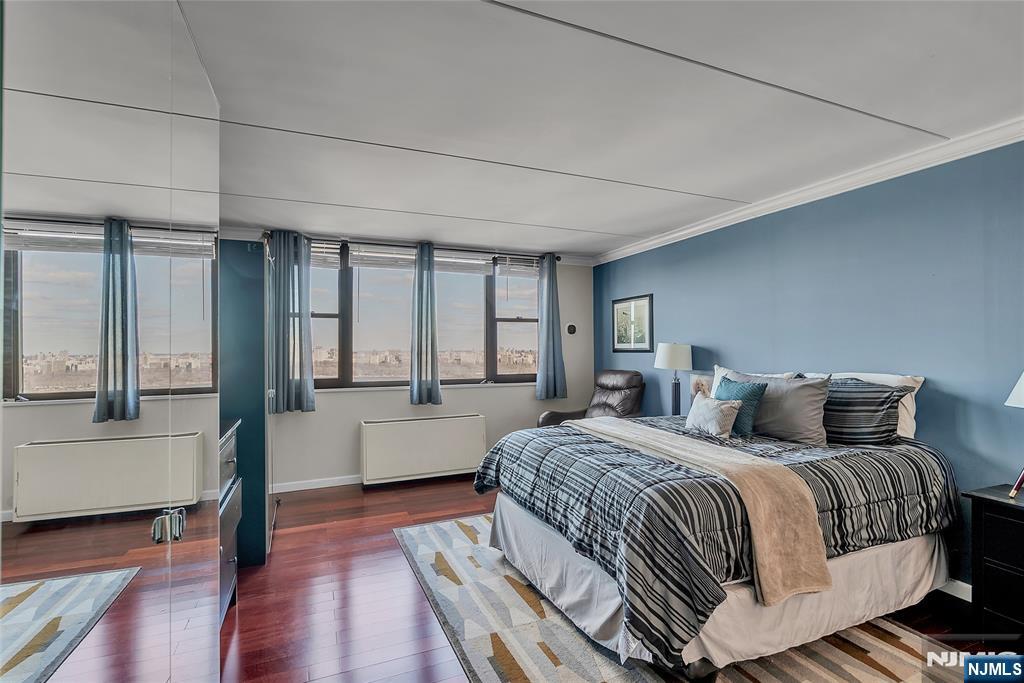 250 Gorge Road, Unit 21B Cliffside Park, NJ 07010 - Photo 17 of 37 a bedroom with a balcony a bed and wooden floor