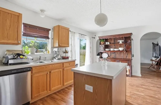 a kitchen with stainless steel appliances granite countertop a sink a stove and a wooden floors