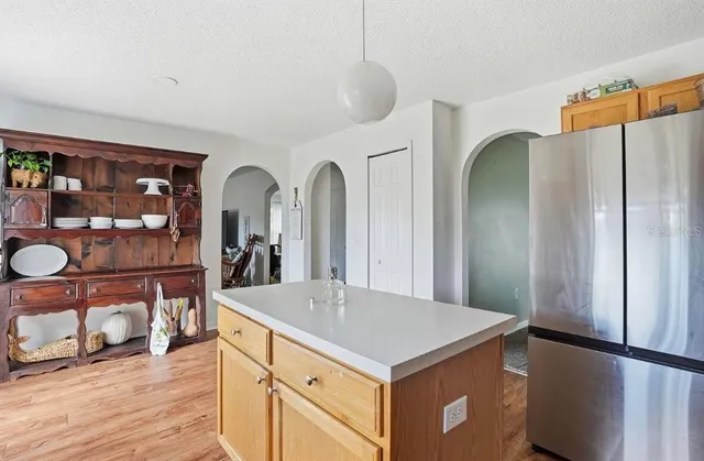 a kitchen with stainless steel appliances a refrigerator and wooden floor