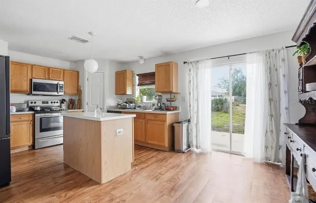 a kitchen with stainless steel appliances a stove top oven a sink a counter space and cabinets