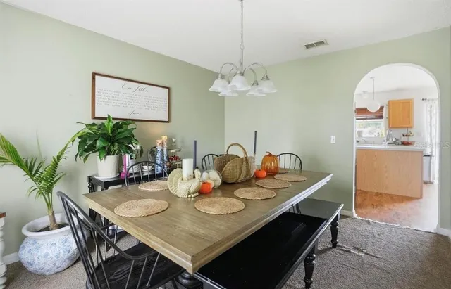 a view of a dining room with furniture and chandelier