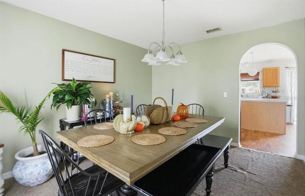 11077 Jenny Wren Road Weeki Wachee, FL 34614 - Photo 15 of 42 a view of a dining room with furniture and chandelier