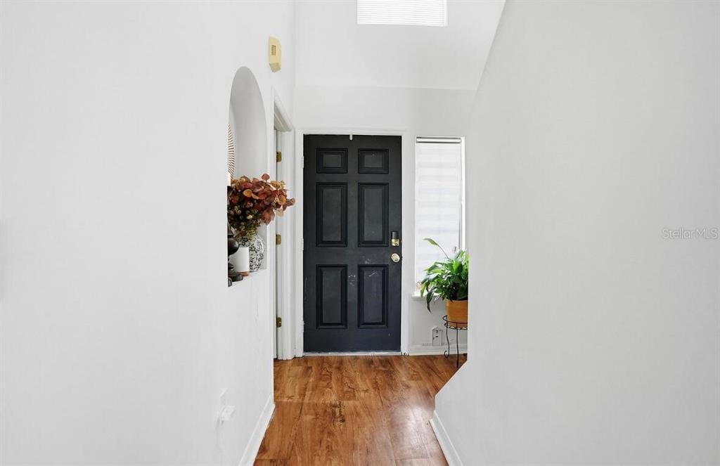 11077 Jenny Wren Road Weeki Wachee, FL 34614 - Photo 20 of 42 a view of a hallway with wooden floor and a potted plant
