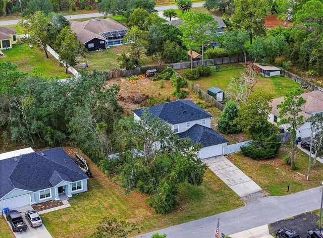 an aerial view of a house with swimming pool and garden