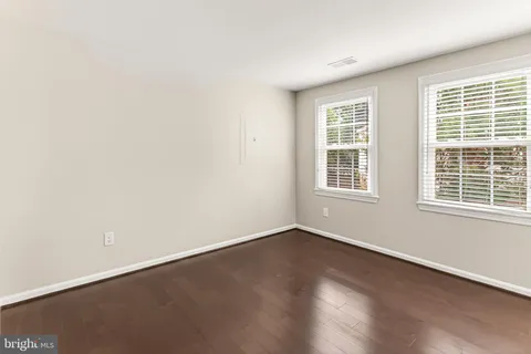 a living room with furniture and a dining table with wooden floor